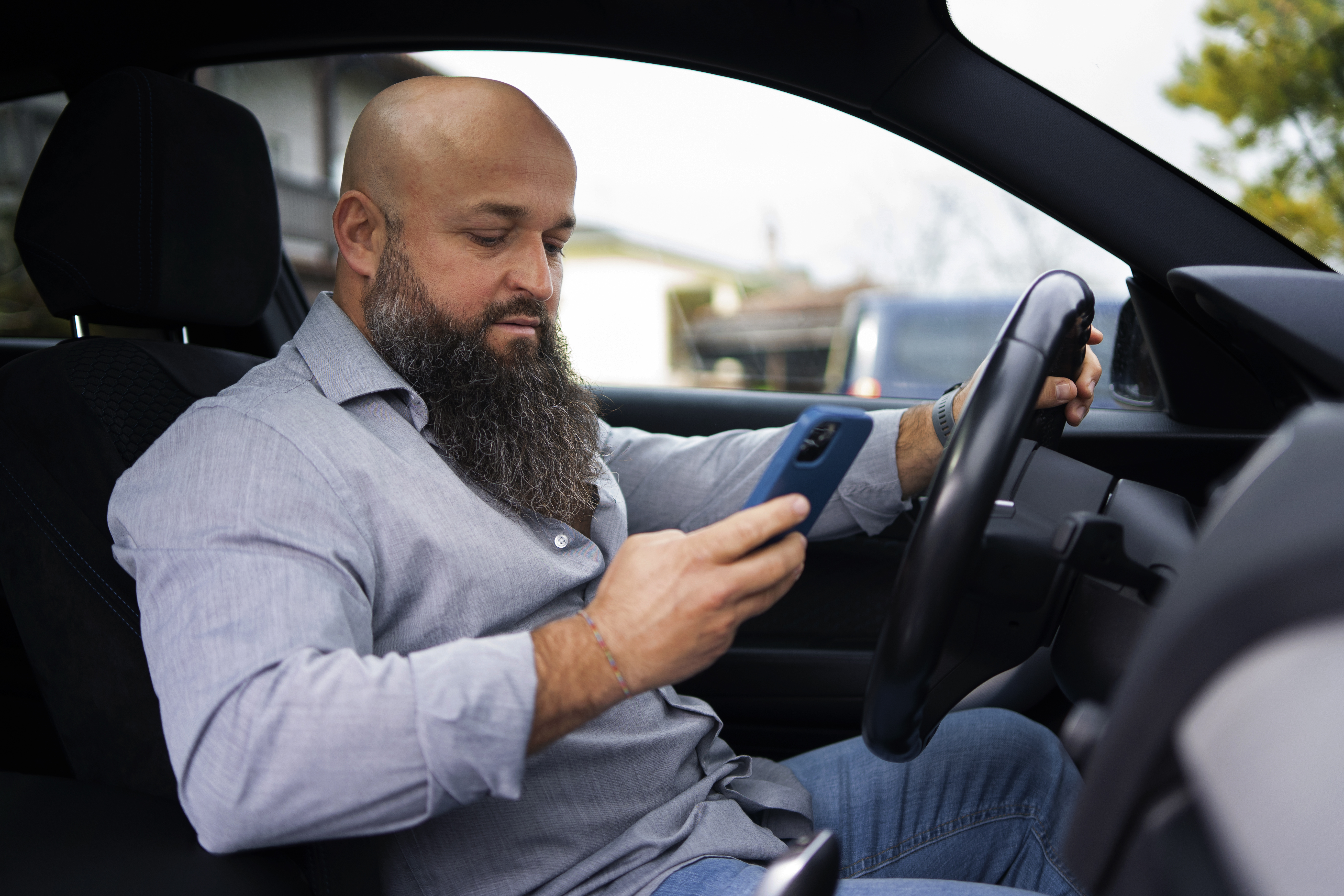 Motorista com smartphone dentro do carro